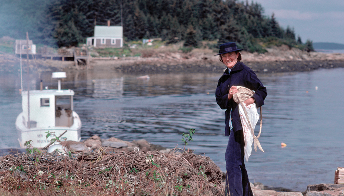 Betsy Wyeth posing for a photo with Benner Island in the background