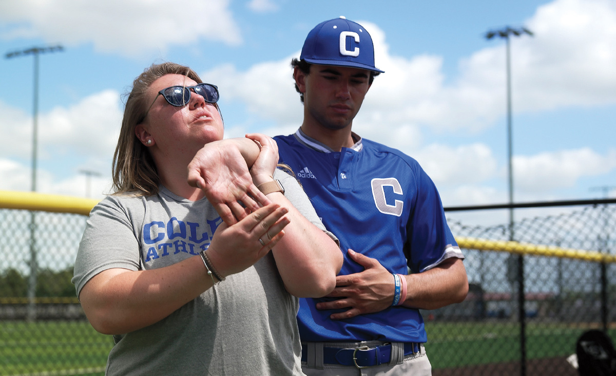 athletic trainer Amanda Lucky working with a Colby baseball player before the start of a game in Davenport, Fla., in March 2023