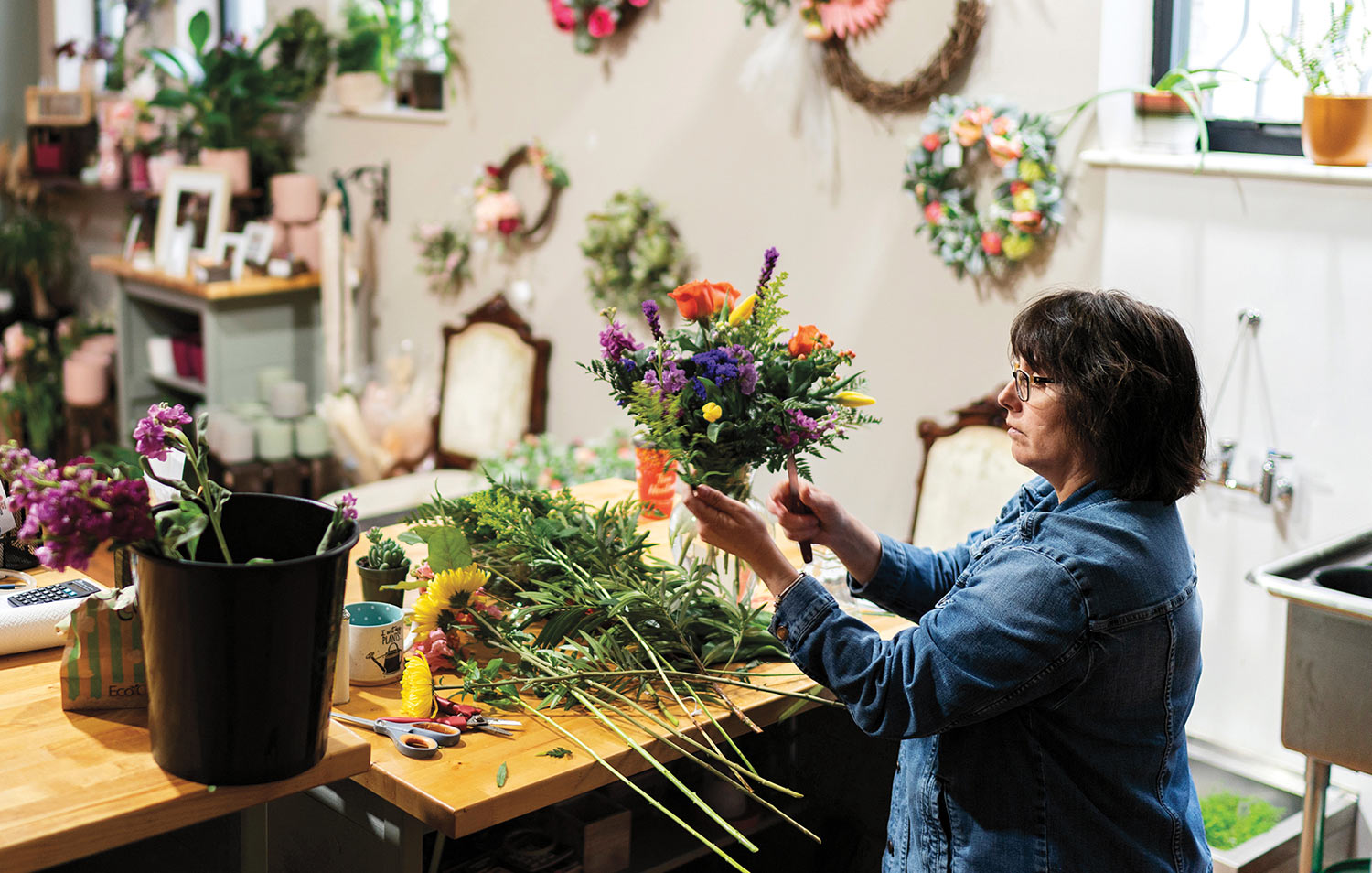 Robin Samalus-Getchell in her shop creating flower arrangement