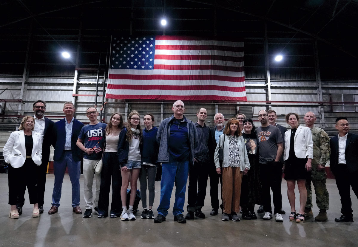 Fletcher Schoen in airport hanger with families he has reunited