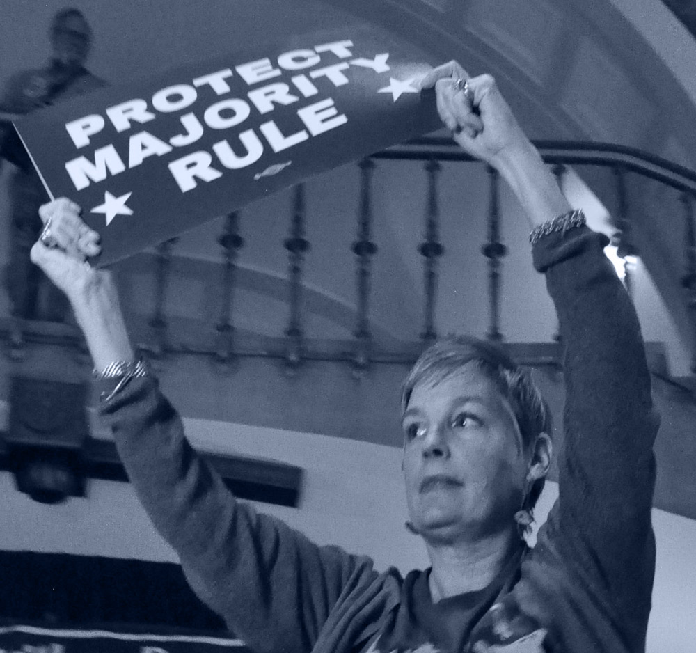 M’Evie Mead holding a sign that reads "Protect Majority Rule."